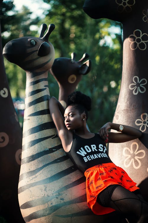 Free Woman Leaning on Zebra Statue Stock Photo