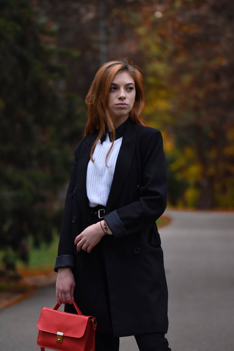 Photo Of A Woman With A Red Purse Looking Away