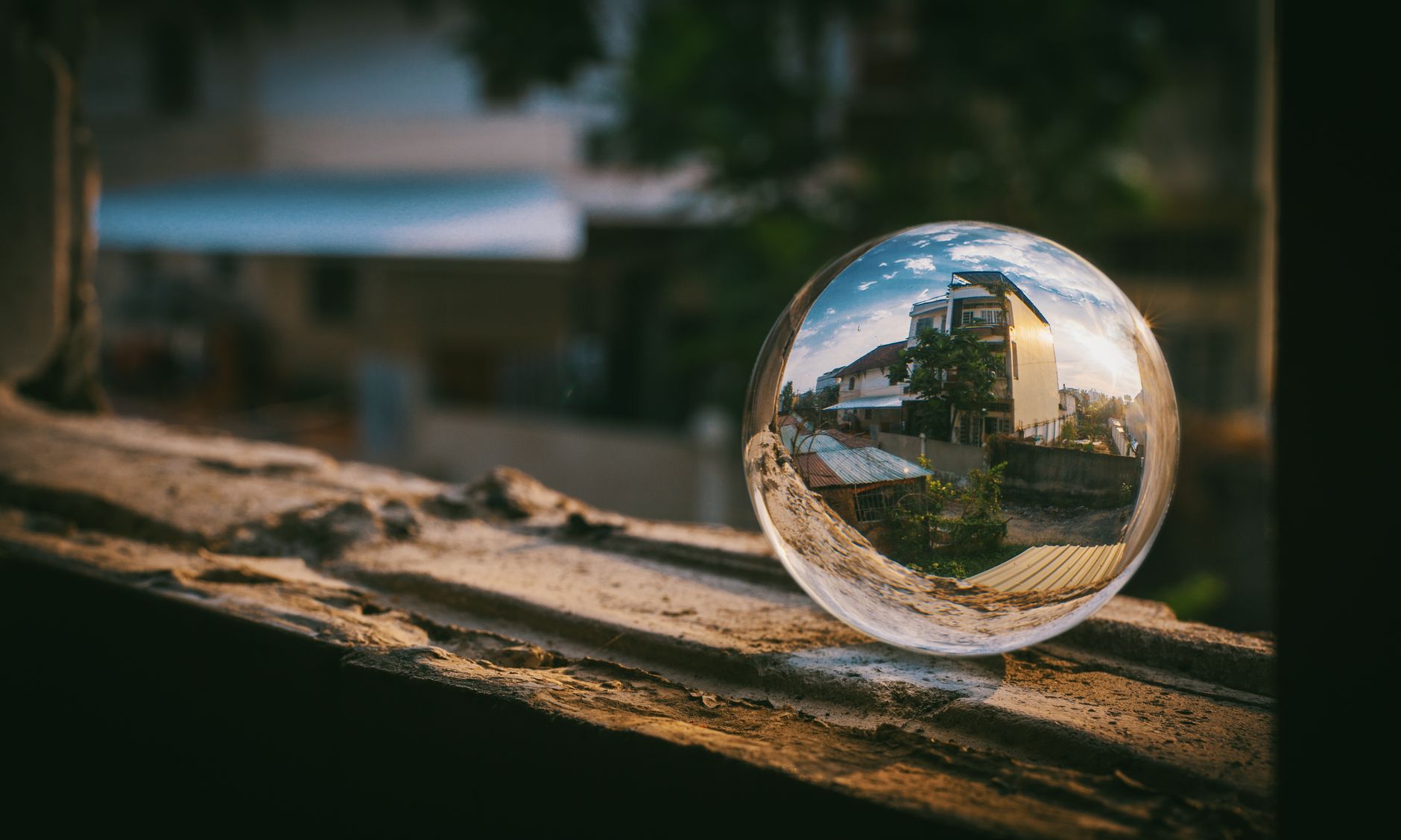 Creative urban scene reflected in a glass sphere on a windowsill, capturing the essence of city life.