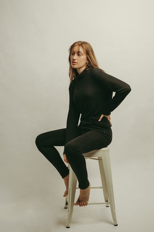 Studio shot of young woman sitting on chair