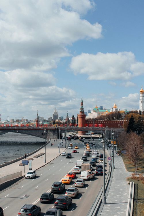 Free View of busy traffic in Moscow near the Kremlin under a clear sky, featuring diverse vehicles. Stock Photo