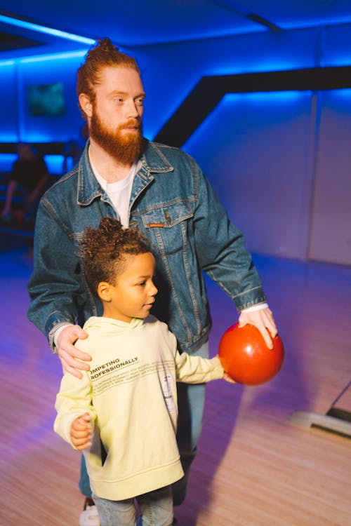 Close-Up Shot of Father and Daughter Holding Bowling Ball