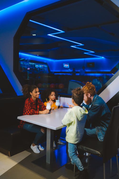 Parents with Kids Sitting at the Table Drinking Juice