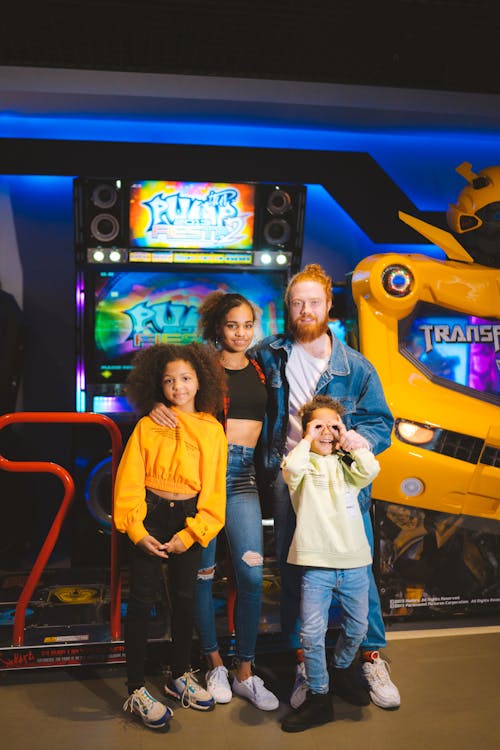 A Family Standing Together in Front of Arcade Machines