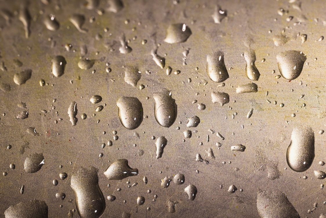 Close-Up Shot of Water Droplets on a Gold Surface · Free Stock Photo