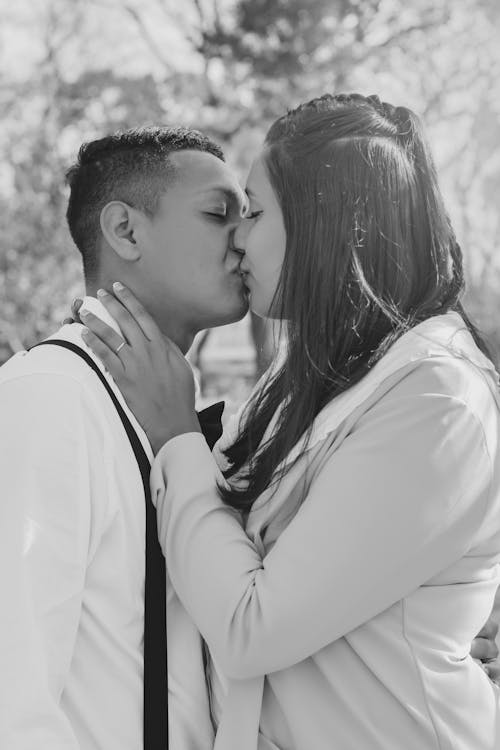 Grayscale Photo of a Romantic Couple Kissing