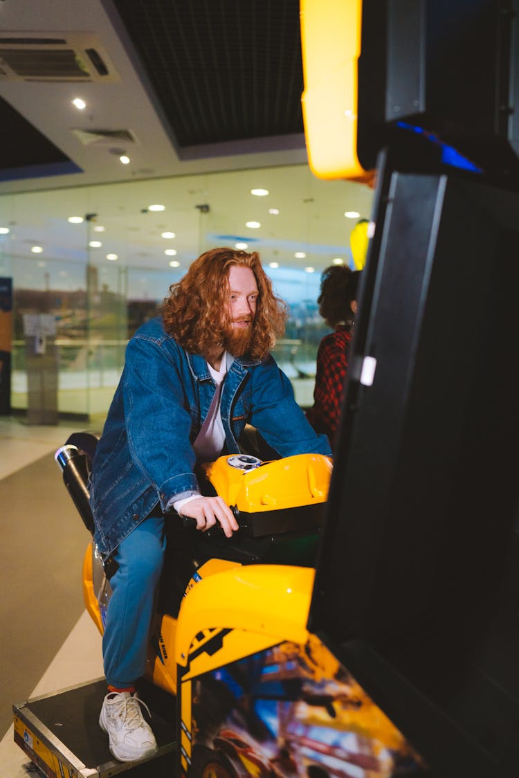 A Man Playing An Arcade Game