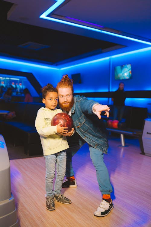 Close-Up Shot of a Father and Son Playing Bowling