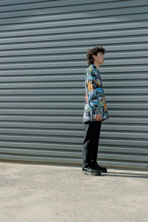 Free Side profile shot of a stylish man in modern fashion against a metallic backdrop. Stock Photo