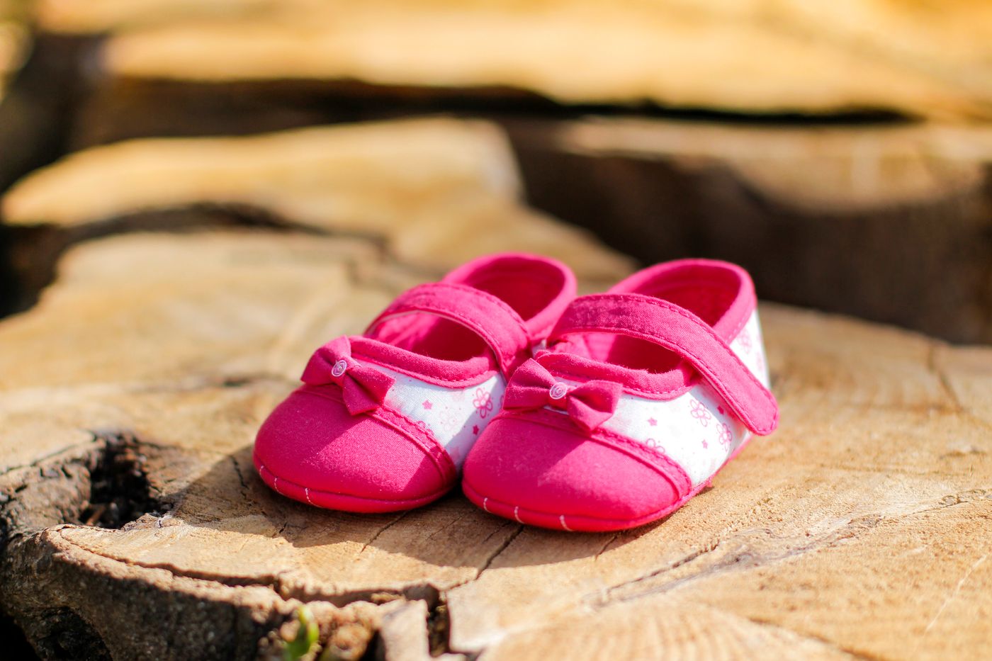 Pink baby shoes placed on a wooden surface