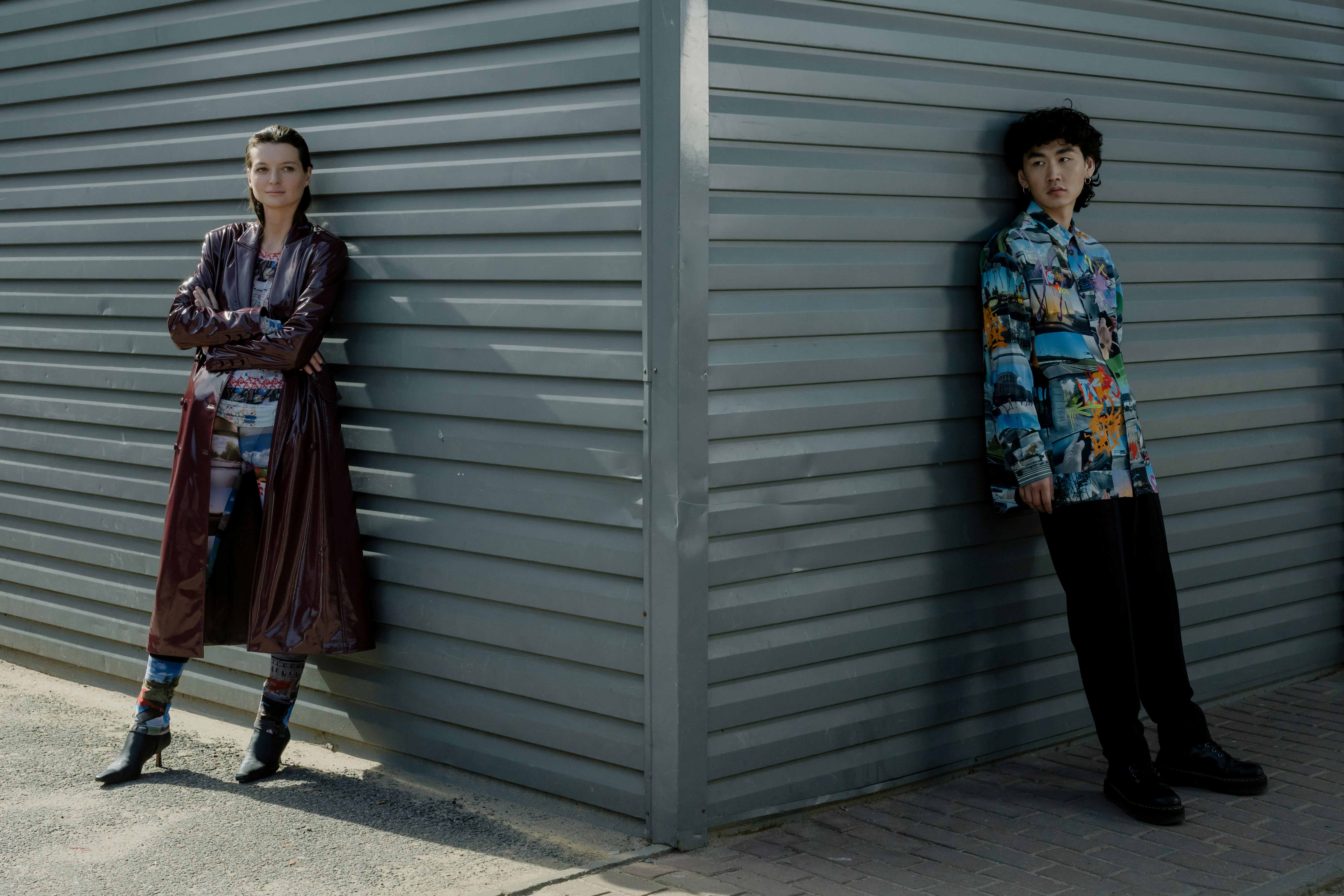 a man and a woman standing near the corrugated wall