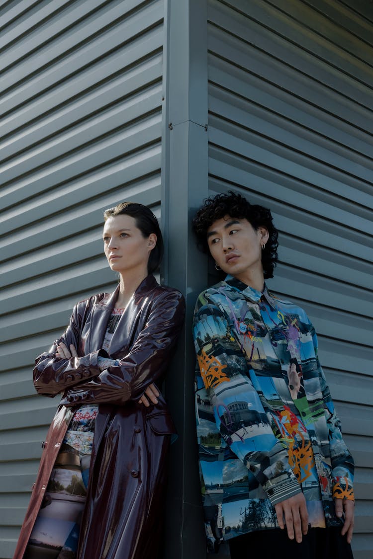 A Woman Wearing Red Leather Coat And A Man Wearing A Printed Long Sleeve Shirt