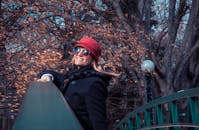 在加拿大基奇纳的秋日里，一位戴着红帽子和太阳镜的女子在户外微笑