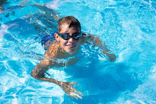 Boy in Braces and Black Goggles in Swimming Pool