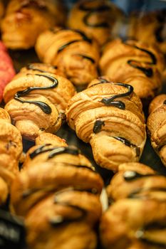 Delicious freshly baked croissants drizzled with chocolate, perfect as a snack or breakfast treat.