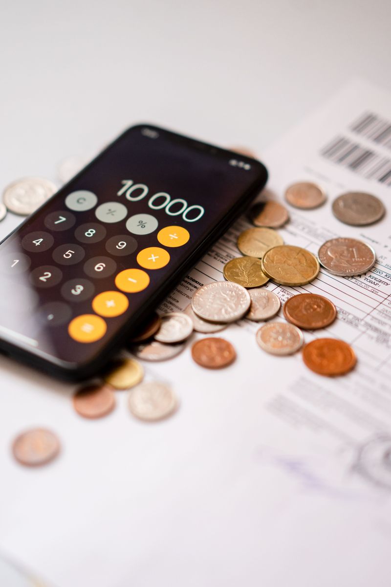 Smartphone calculator with coins and financial documents