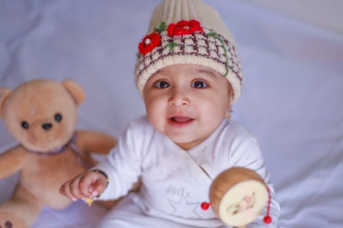 Free Close-Up Shot of a Cute Baby in a Beige Knitted Cap Smiling Stock Photo