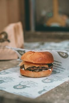 Mouthwatering cheeseburger with melted cheese on a wrapper, perfect for food photography enthusiasts.