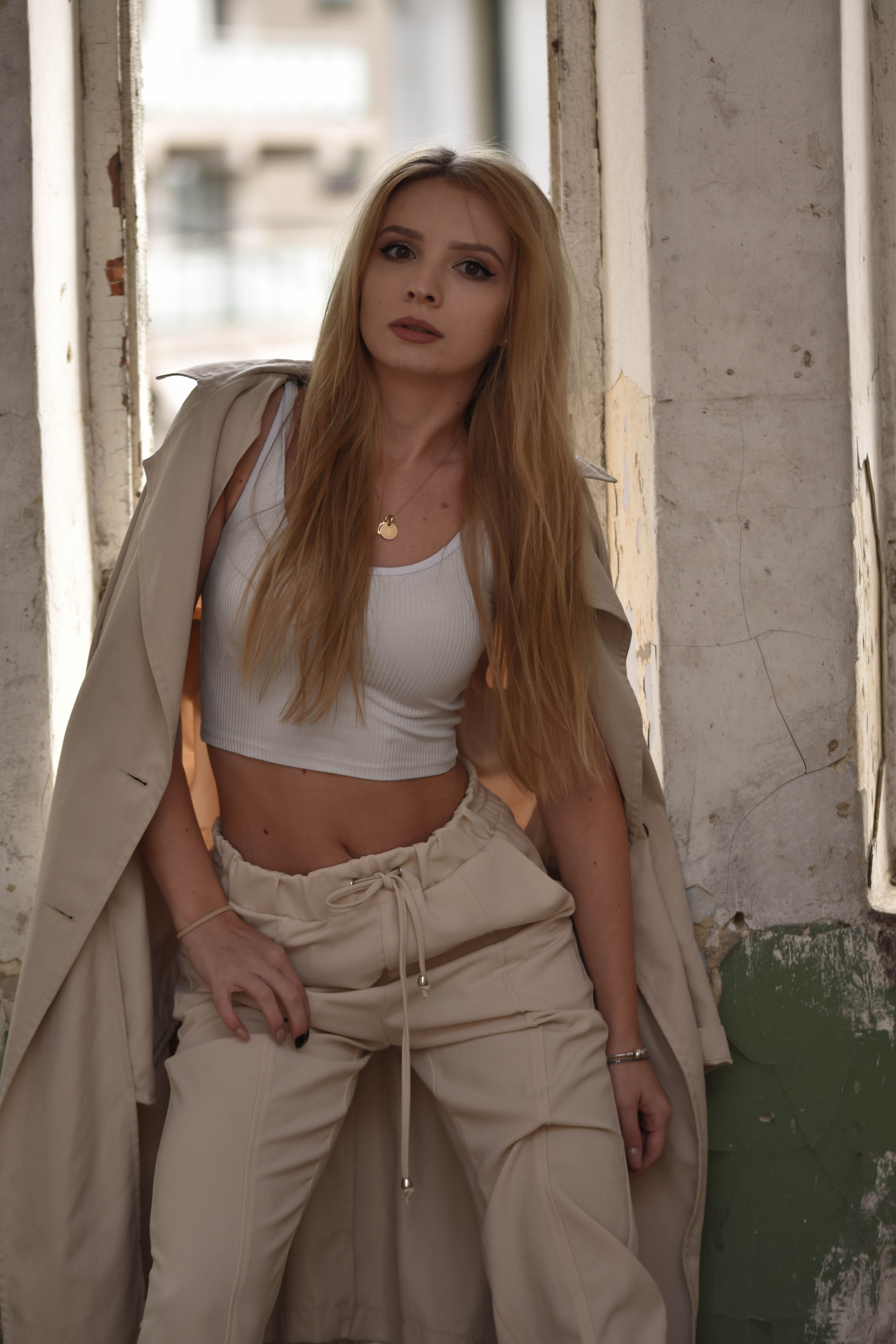 Model in trendy beige outfit posing in an industrial-style space.