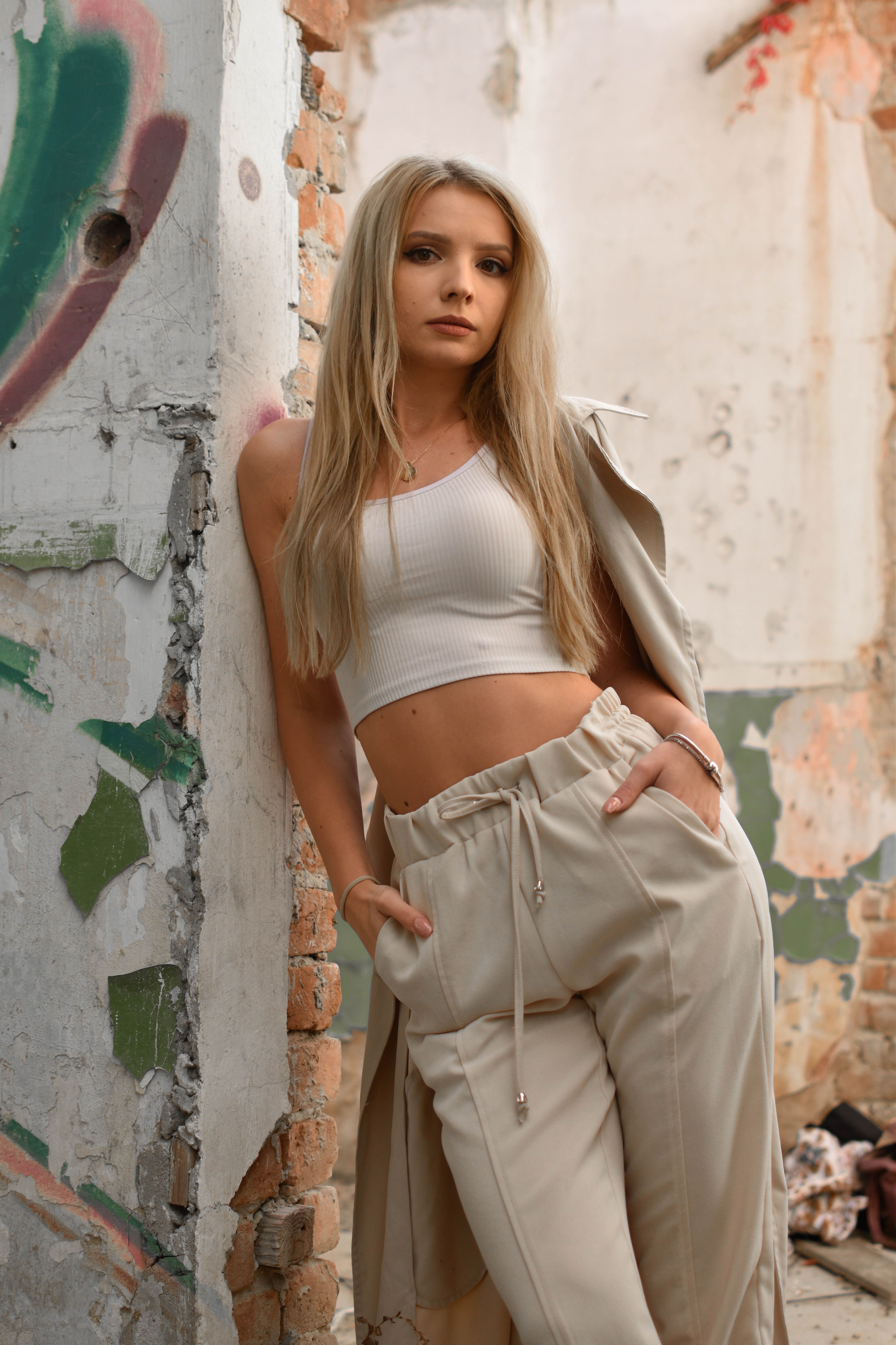 Model posing in trendy attire against urban graffiti wall. Stylish and edgy fashion photography.