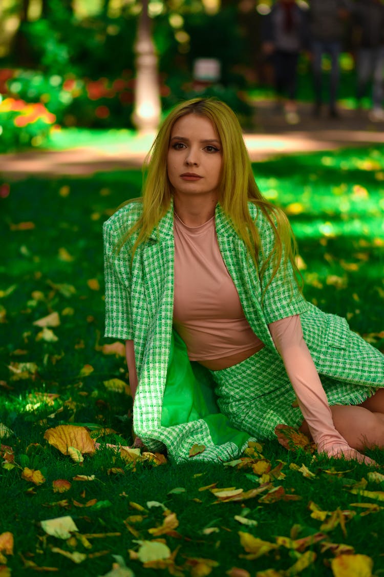 Woman In Green Plaid Skirt Sitting On Green Grass