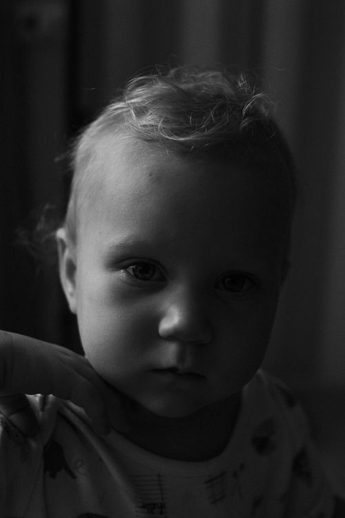 Free Close-up black and white portrait of a child with an introspective expression. Stock Photo