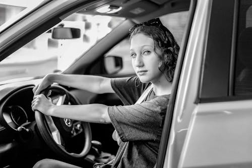 Free Grayscale Photo of a Woman Inside the Car Stock Photo