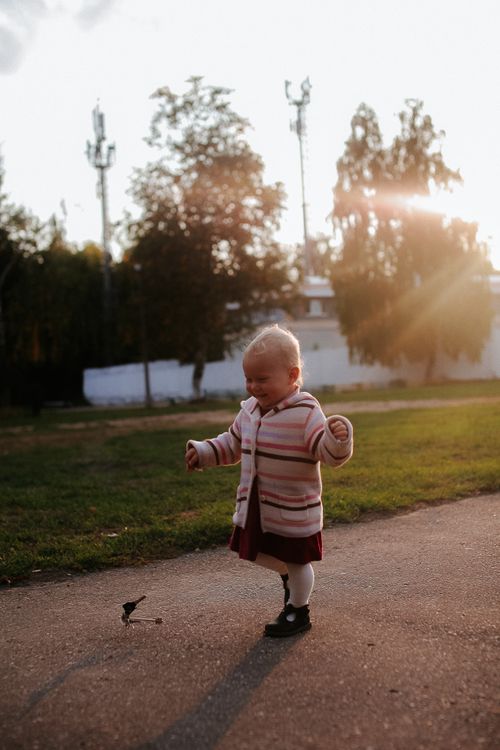 Free Cute toddler smiling and walking in a sunlit park, embracing nature. Stock Photo