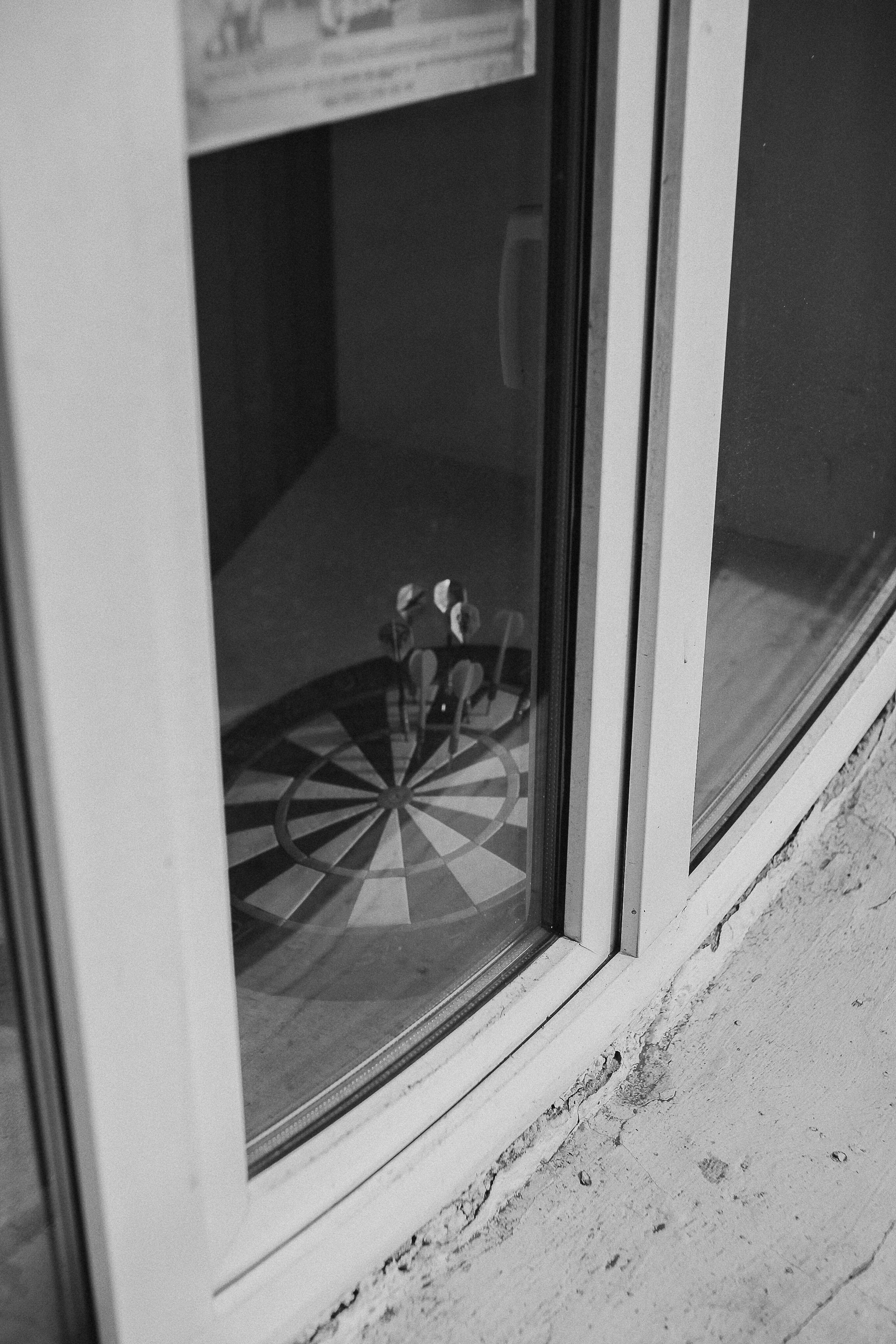 A dartboard reflected in glass, an artistic black and white composition.