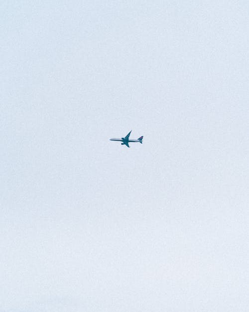 Free A Blue Airplane Flying in the Sky Stock Photo