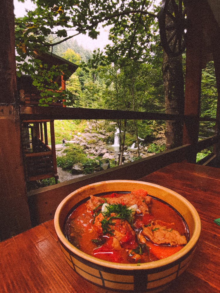 A Bowl Of Chili Soup On A Wooden Table