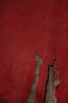Detailed view of a textured and cracked red wall, perfect for backgrounds or design elements.