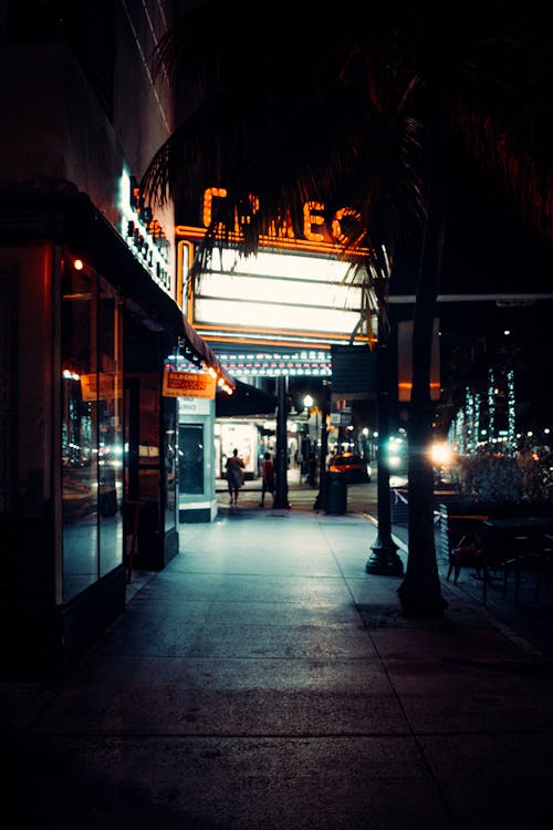 Sidewalk Beside Theatre with Neon Sign at Night