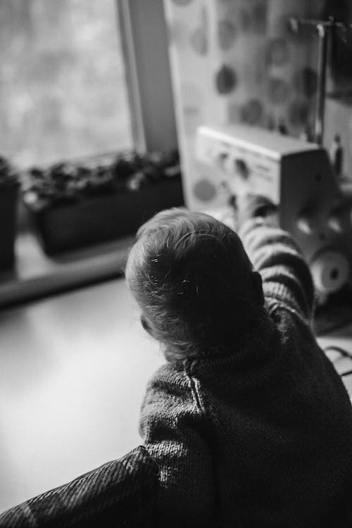 Grayscale Photo of Child in Sweater