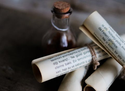 A rustic scene with rolled vintage scrolls and a small apothecary bottle on a wooden surface.