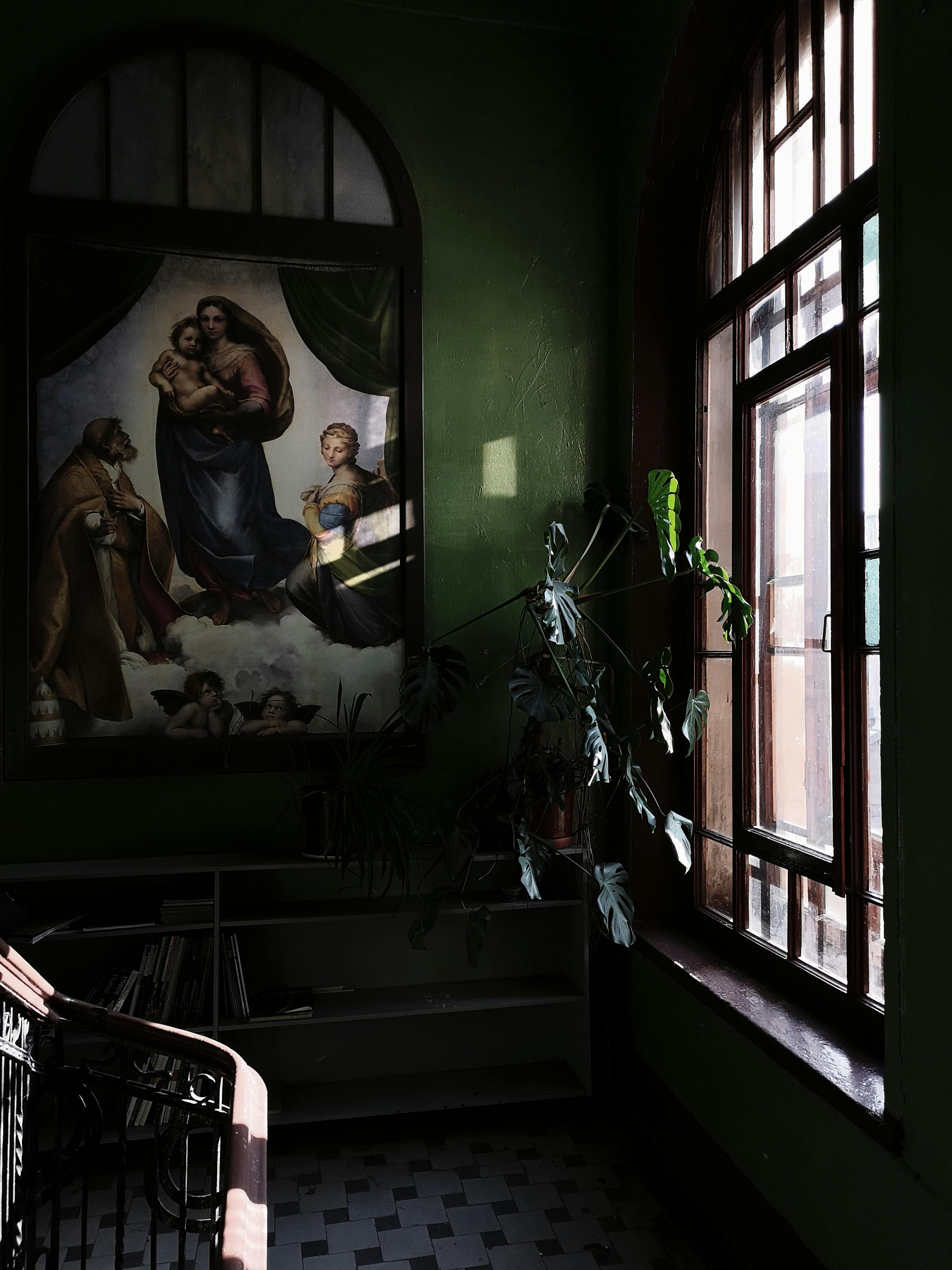 Free A serene space showcasing religious art and natural light through a window. Stock Photo