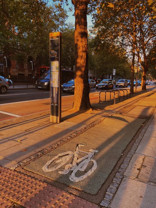 Free Urban street scene featuring a bicycle lane at sunset, creating a warm and inviting atmosphere. Stock Photo
