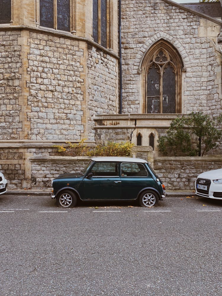 Side View Of A Vintage Car Parked On The Side Of The Road