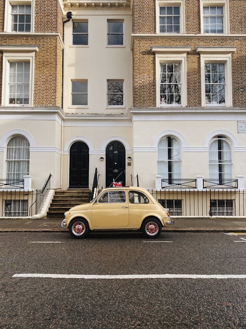 Yellow Car Parked Beside the Concrete Building