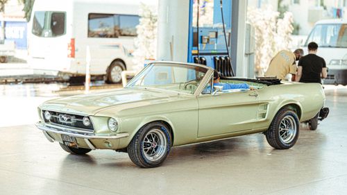 Free Classic Ford Mustang convertible parked at a Turkish gas station with people around. Stock Photo