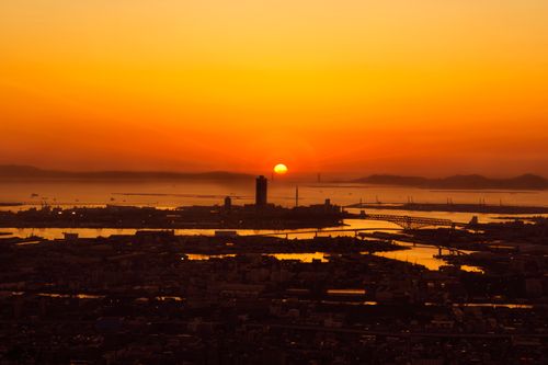 Free A breathtaking aerial view of an urban sunset with vibrant orange hues over a cityscape. Stock Photo