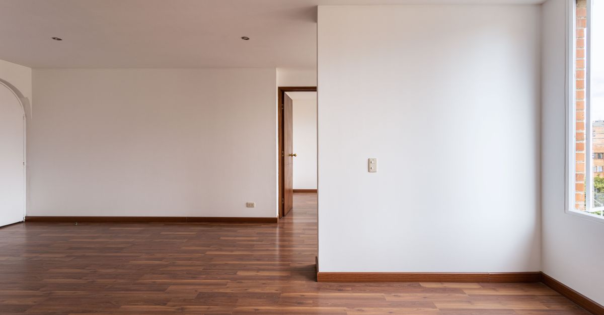 Empty room with wooden floors and white walls, ideal for real estate or interior design concepts.