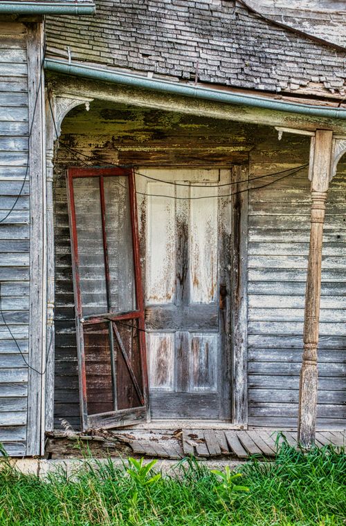Free A weathered wooden doorway with peeling paint on an abandoned house in Minnesota. Perfect for rustic themes. Stock Photo