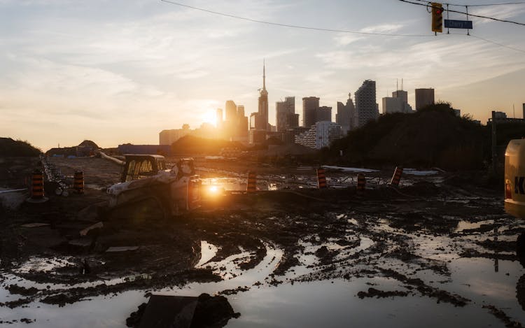 Tractor Working In Mud On Sunset