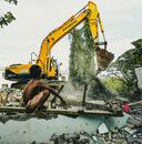 Man in Black Shorts Sitting on Yellow Excavator