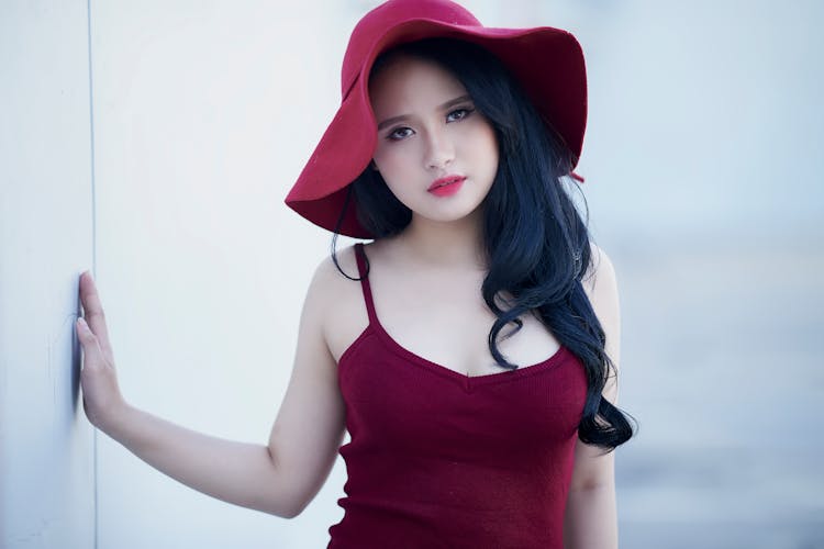 A Girl In Red Tank Top Wearing A Red Hat