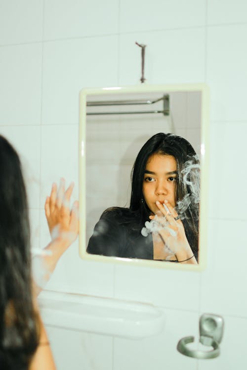 Reflection of a Smoking Woman in the Mirror