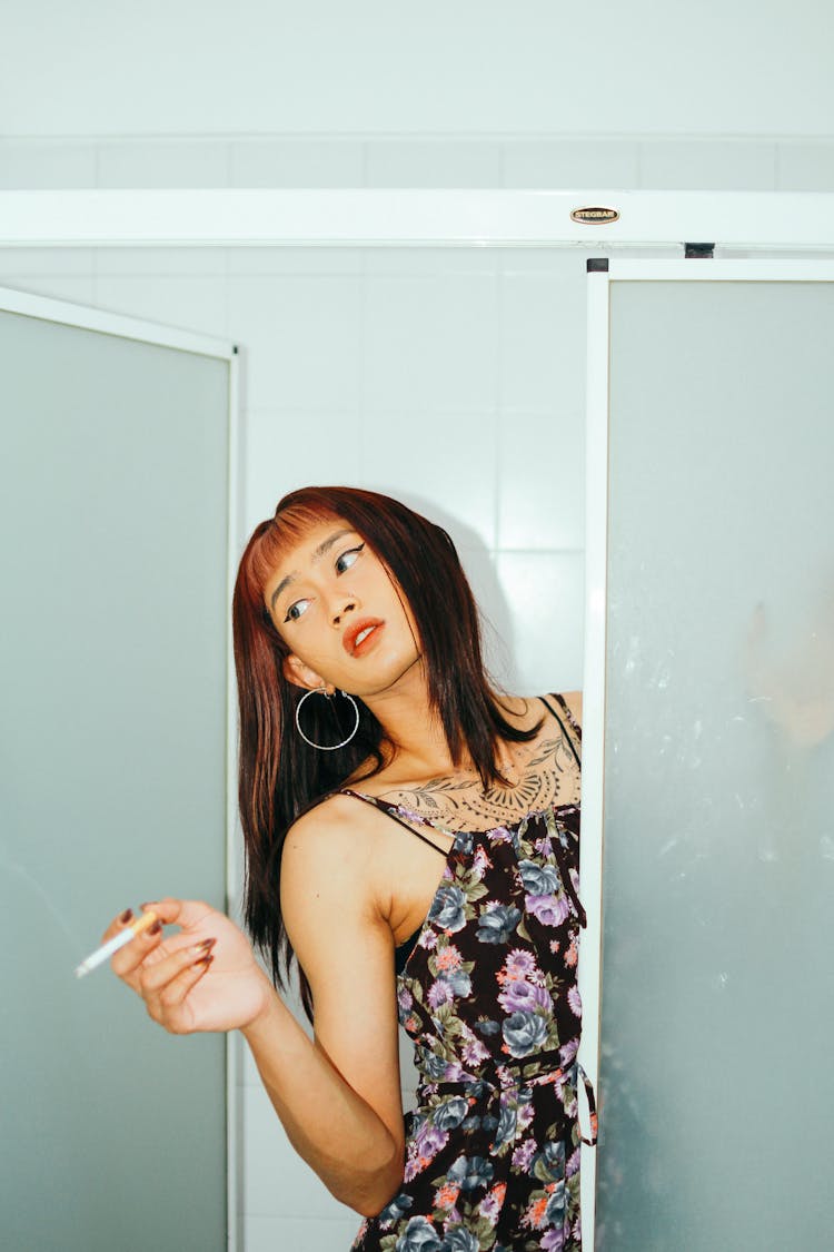 A Girl In A Shower Room Holding A Cigarette