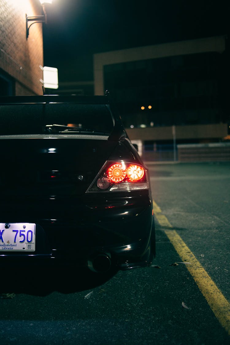 A Lighted Tail Light Of A  Black Car