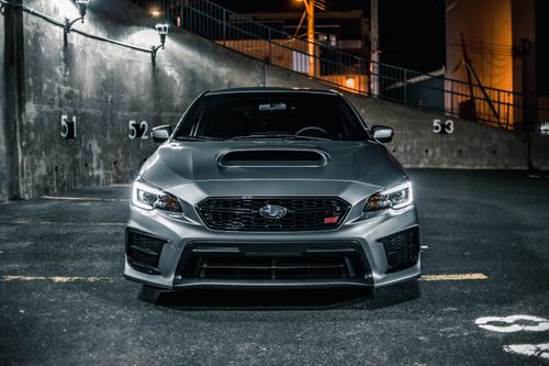Free A sleek gray car parked in an urban setting at night, with dramatic lighting. Stock Photo